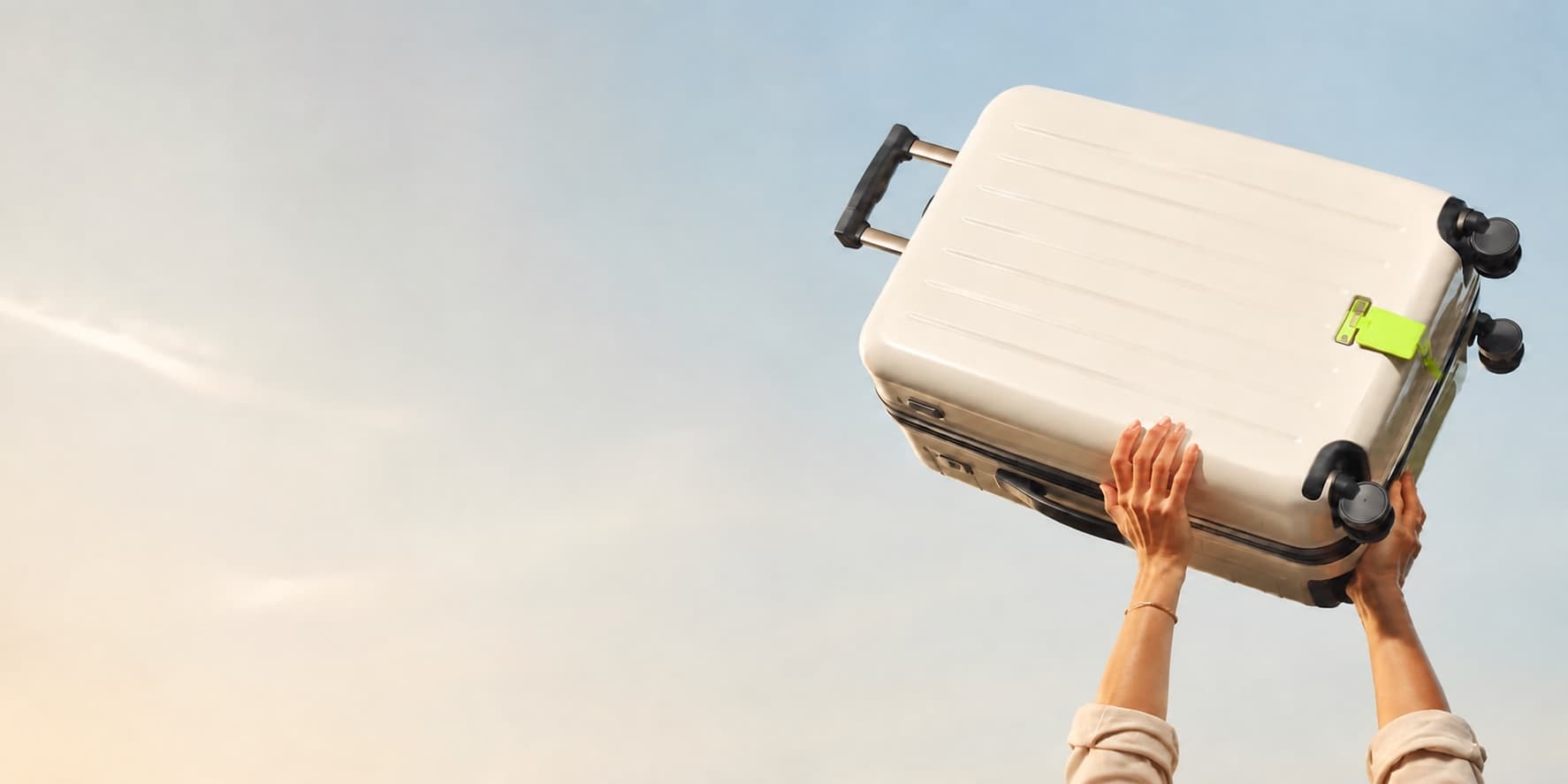 Cream suitcase lifted into the air for an Amwal travel installment journey